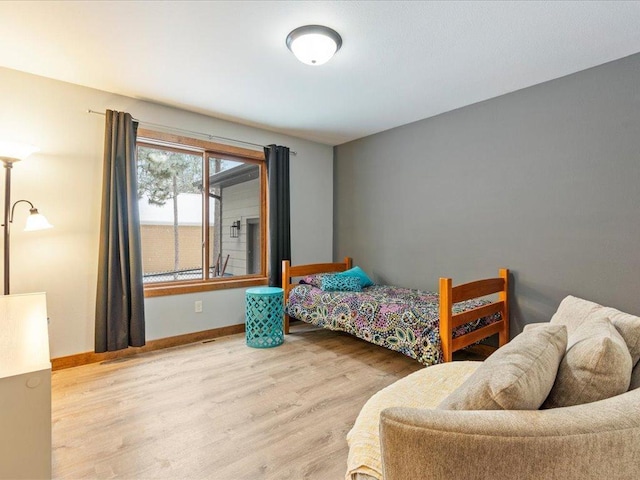 bedroom with baseboards and wood finished floors