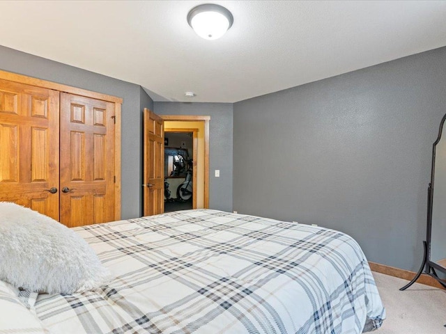 bedroom featuring light carpet, baseboards, and a closet