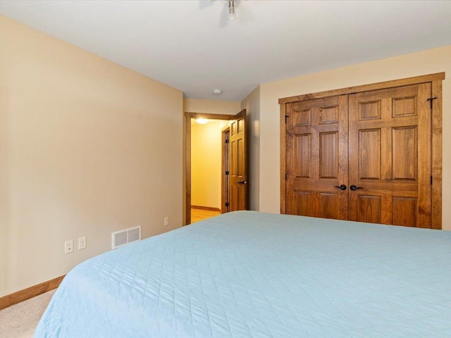 carpeted bedroom featuring baseboards and visible vents