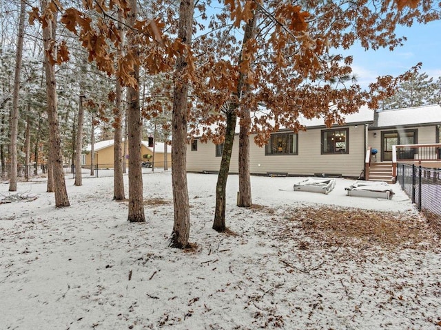 snow covered rear of property with fence