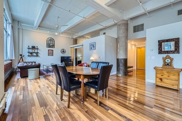 dining area with light wood-type flooring, visible vents, ceiling fan, and beamed ceiling