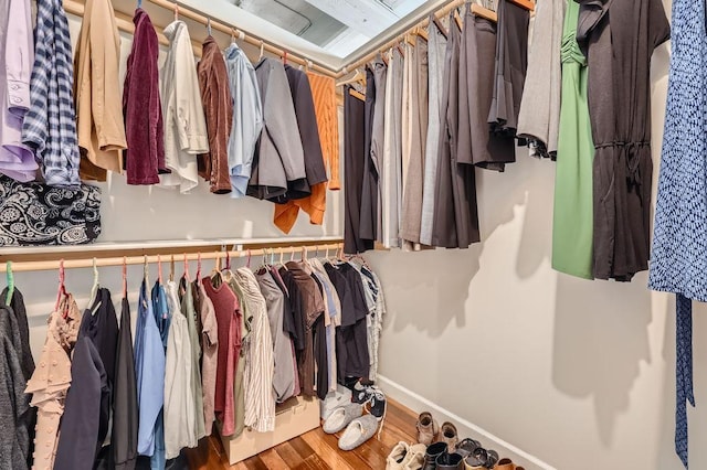 walk in closet with wood finished floors