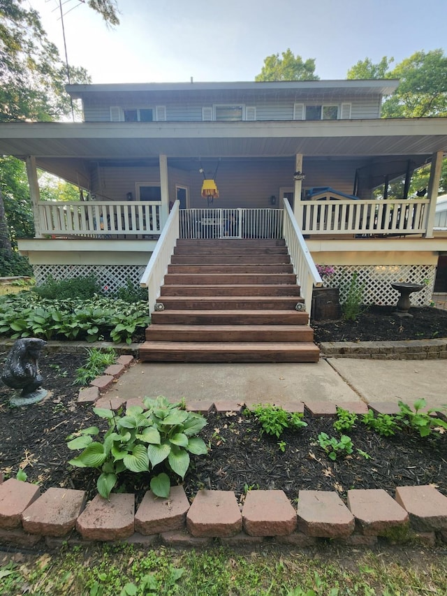 back of property with stairs and a porch