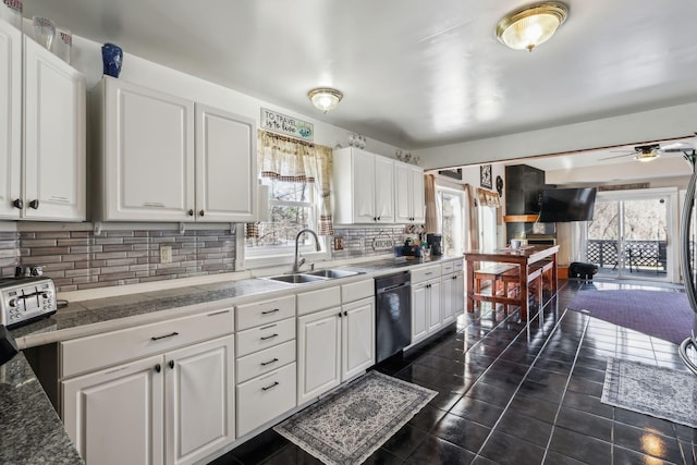 kitchen with black dishwasher, tile counters, white cabinets, and a sink