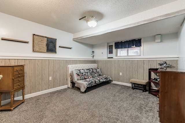 living area featuring carpet floors, a wainscoted wall, wooden walls, and a textured ceiling