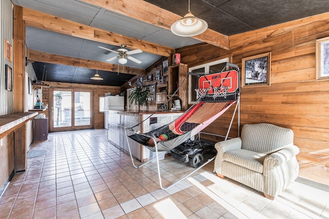 unfurnished room featuring lofted ceiling with beams, wood walls, tile patterned flooring, and a ceiling fan