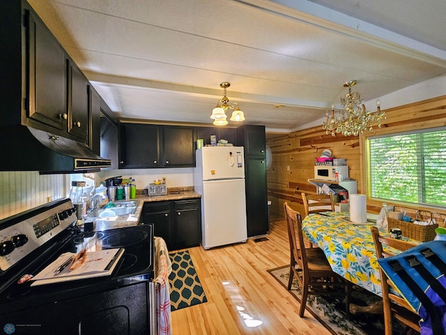 kitchen with stainless steel range with electric cooktop, dark cabinetry, freestanding refrigerator, an inviting chandelier, and a sink