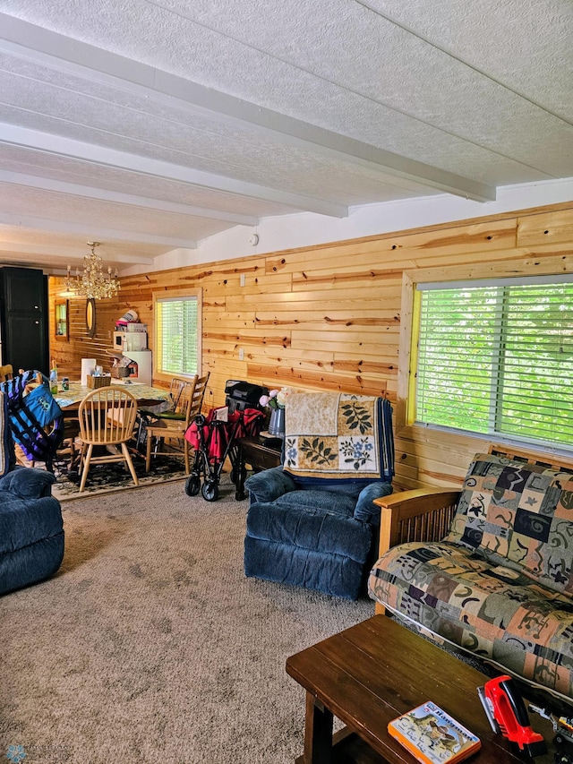 living room featuring beam ceiling, carpet flooring, wood walls, and a textured ceiling