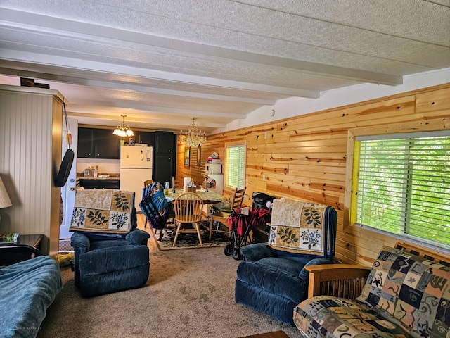 carpeted living area with beam ceiling, wooden walls, a textured ceiling, and a notable chandelier