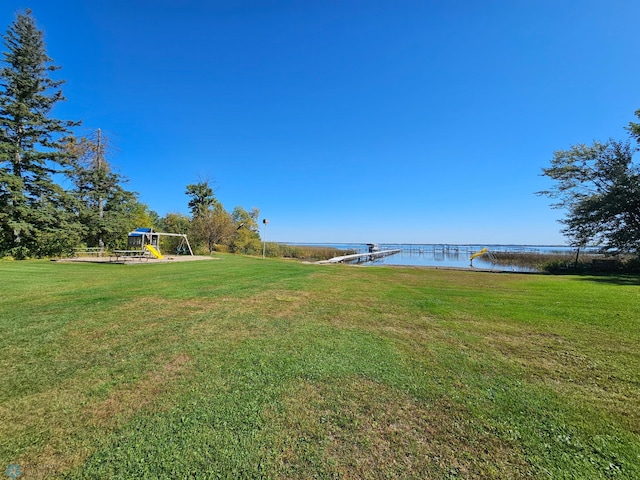 view of yard with playground community and a water view