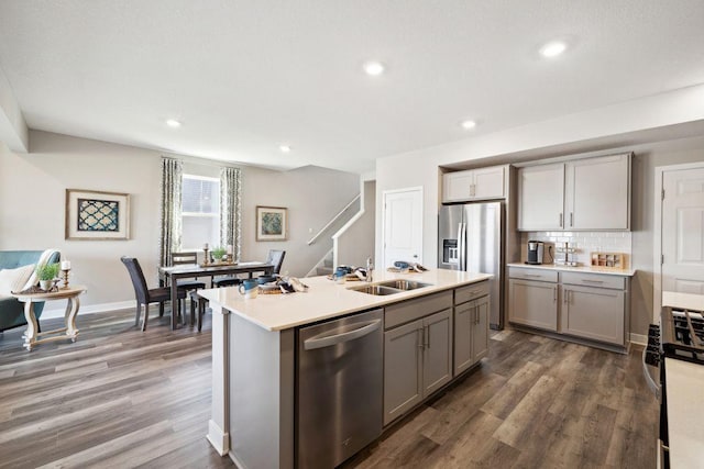 kitchen featuring gray cabinets, dark wood-style flooring, stainless steel appliances, and a sink