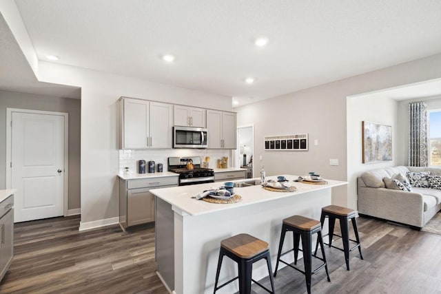 kitchen featuring gray cabinets, stainless steel appliances, dark wood-style flooring, and light countertops