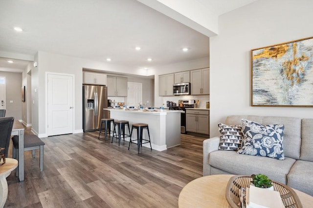 living area featuring baseboards, dark wood-style flooring, and recessed lighting