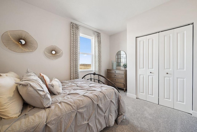 carpeted bedroom featuring a closet and baseboards