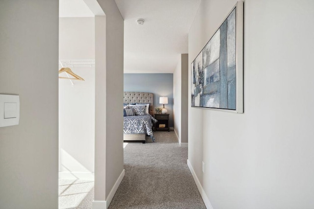 corridor featuring carpet flooring and baseboards