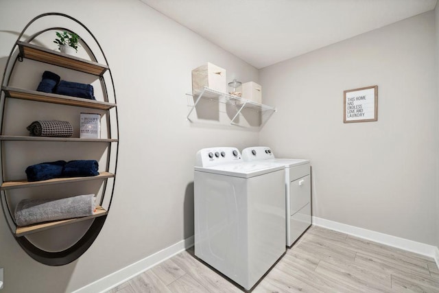 laundry room featuring laundry area, washing machine and dryer, baseboards, and light wood-style flooring