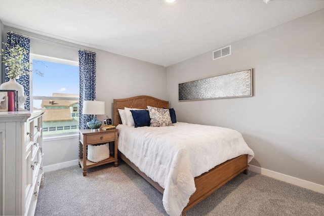 bedroom with light carpet, visible vents, and baseboards