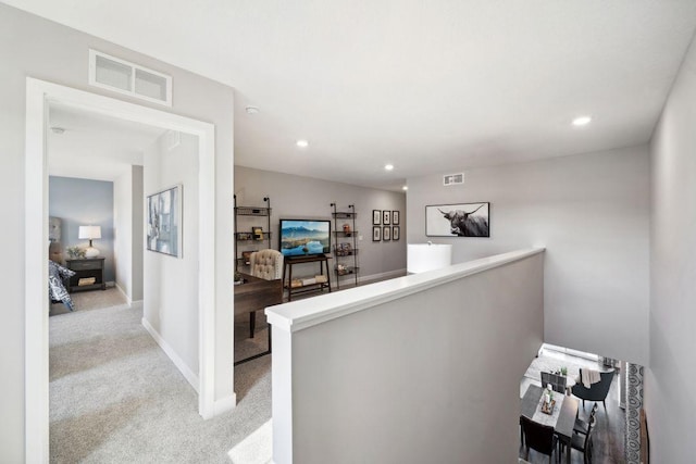 corridor featuring recessed lighting, visible vents, carpet flooring, and an upstairs landing