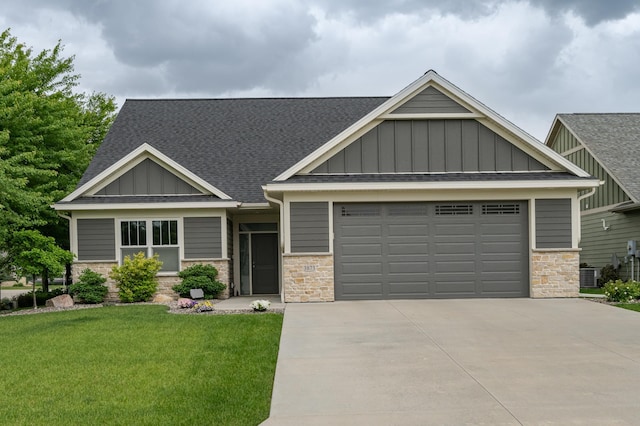 craftsman inspired home featuring a garage, driveway, stone siding, a front lawn, and board and batten siding