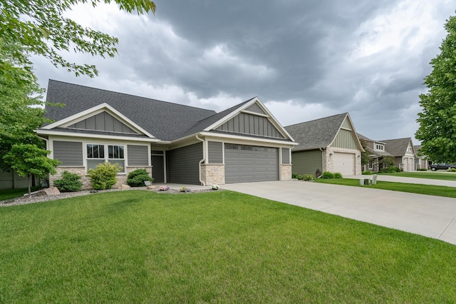 craftsman-style home featuring board and batten siding, a front yard, concrete driveway, and a garage