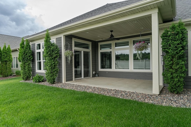 rear view of house featuring a patio area, roof with shingles, ceiling fan, and a yard