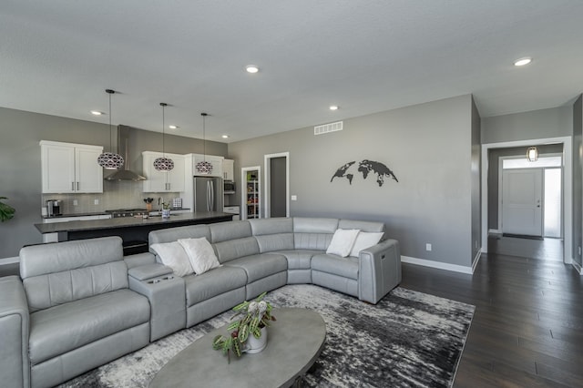 living area with dark wood-type flooring, recessed lighting, visible vents, and baseboards