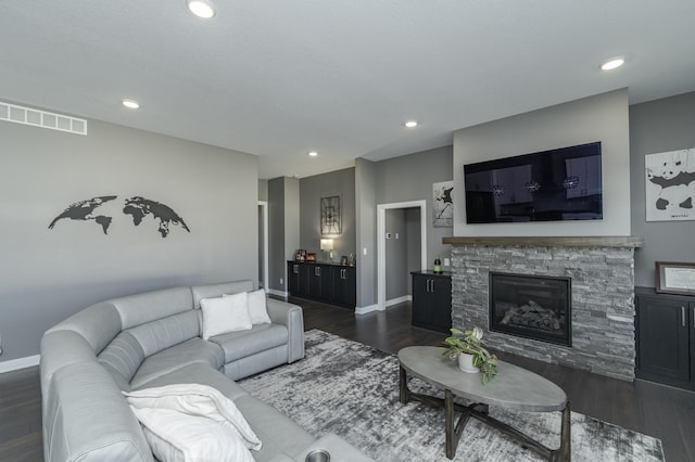 living area with dark wood-style flooring, visible vents, and recessed lighting