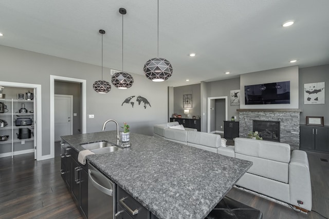 kitchen featuring dark wood-style floors, a fireplace, recessed lighting, stainless steel dishwasher, and open floor plan