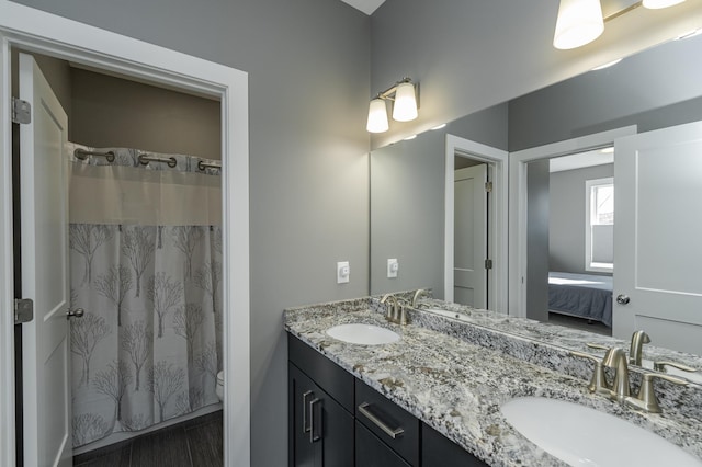 full bathroom featuring double vanity, toilet, a sink, and ensuite bathroom