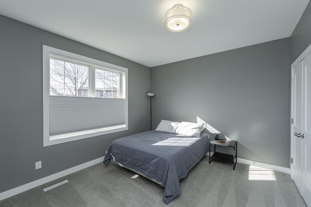 carpeted bedroom featuring visible vents and baseboards