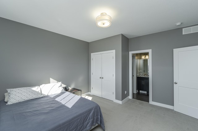 bedroom featuring baseboards, visible vents, connected bathroom, carpet flooring, and a closet