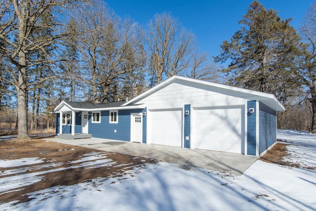 9806 County Road 144, Brainerd, MN 56401 - snow covered garage featuring concrete driveway