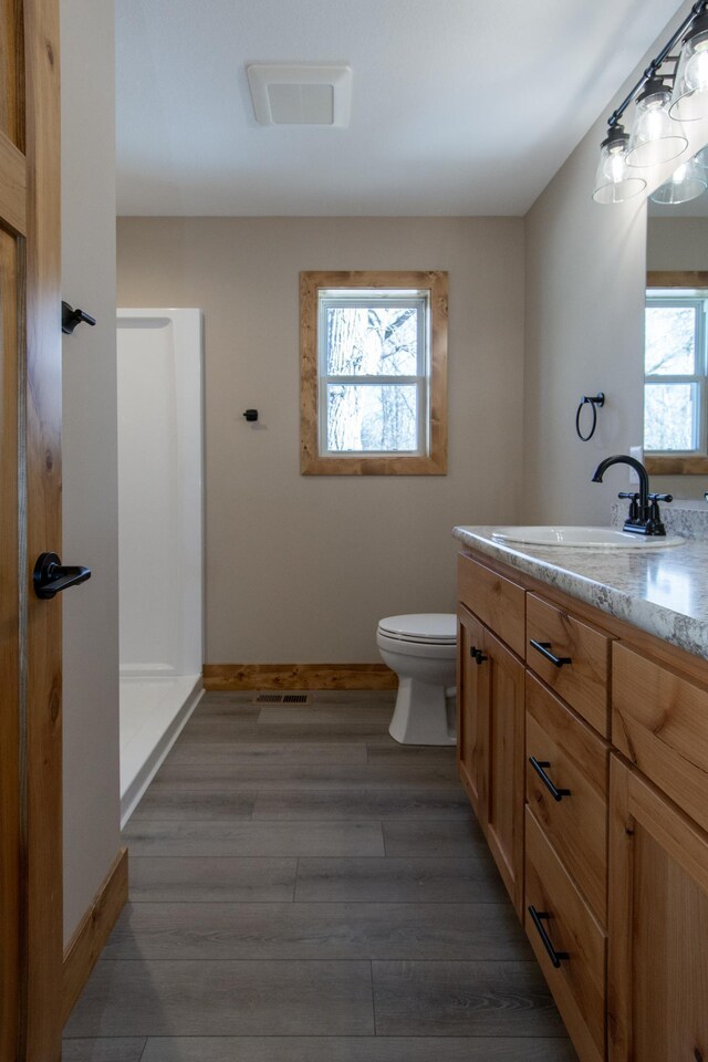9806 County Road 144, Brainerd, MN 56401 - bathroom featuring toilet, vanity, wood finished floors, and baseboards