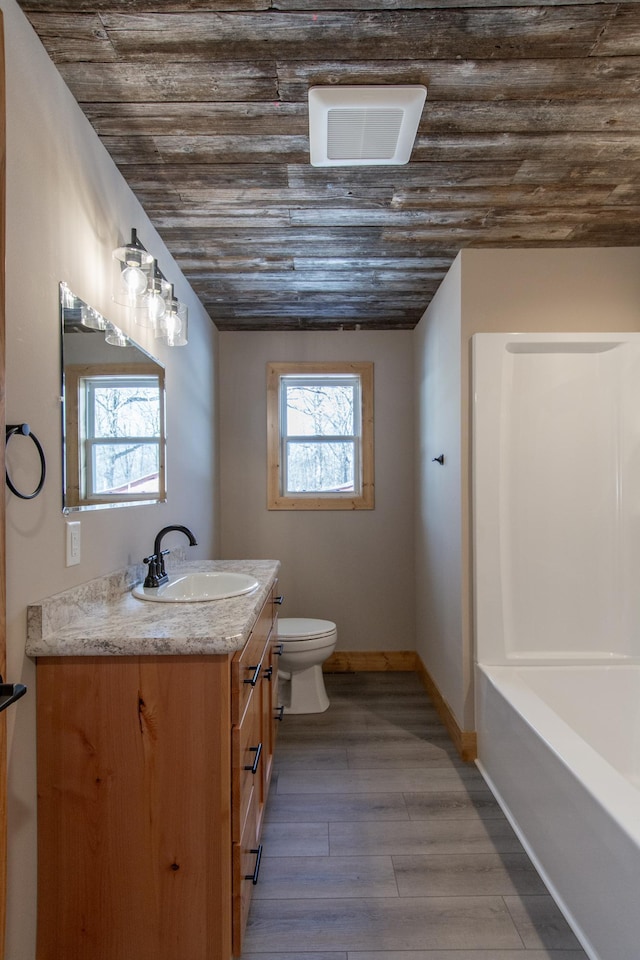 9806 County Road 144, Brainerd, MN 56401 - bathroom featuring baseboards, wooden ceiling, toilet, vanity, and wood finished floors