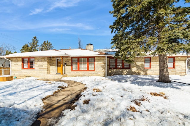 single story home featuring stone siding and a chimney