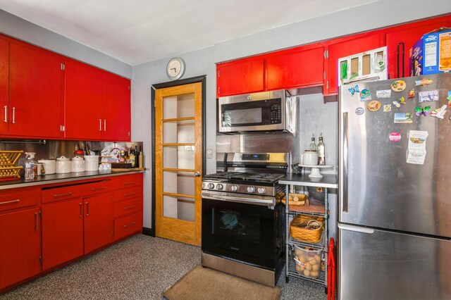 kitchen featuring appliances with stainless steel finishes and red cabinetry