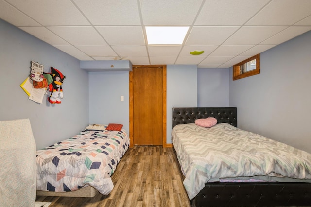 bedroom featuring a paneled ceiling and wood finished floors