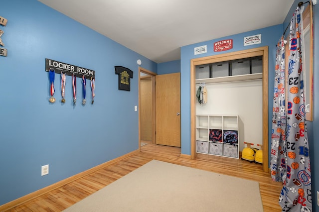 bedroom featuring a closet, baseboards, and wood finished floors