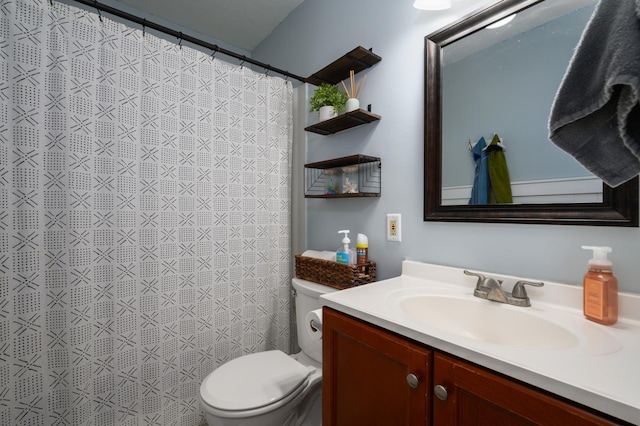 bathroom featuring curtained shower, vanity, and toilet