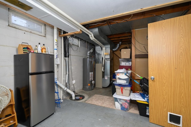 below grade area with heating unit, water heater, and freestanding refrigerator