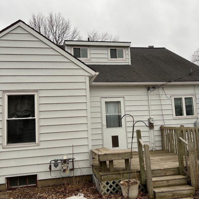 rear view of house with roof with shingles and a deck