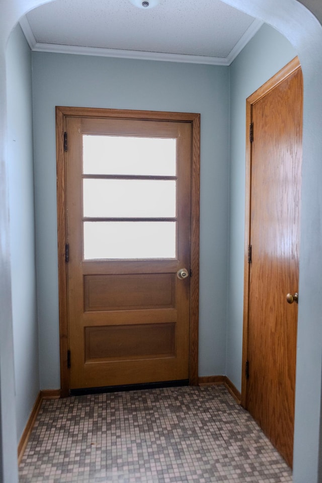 entryway featuring arched walkways, ornamental molding, and baseboards