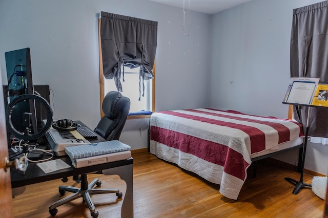 bedroom with baseboards and wood finished floors