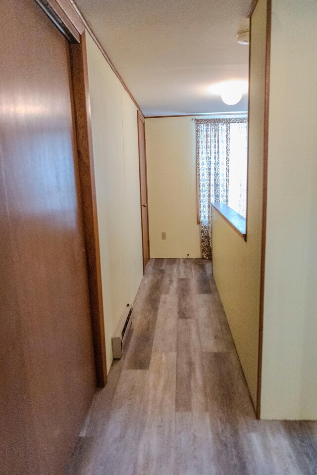 hall with light wood-style floors and baseboard heating