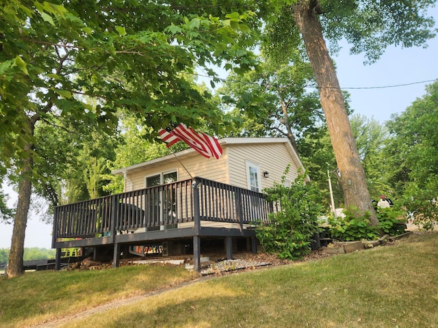 rear view of property with a deck and a lawn