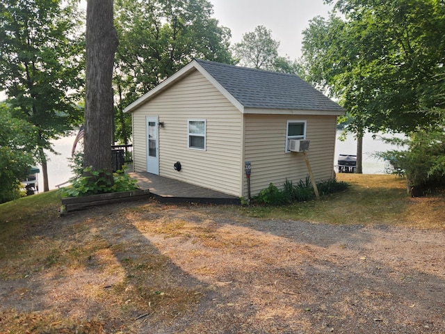 view of property exterior with a shingled roof and cooling unit