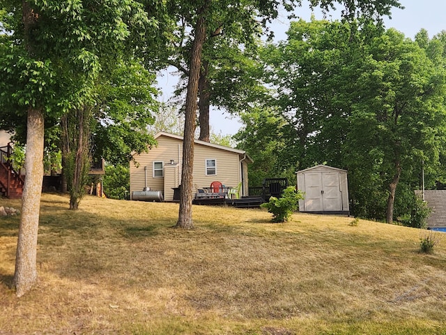 view of yard featuring an outbuilding, a storage unit, and a deck