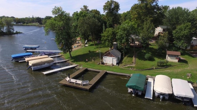 view of dock with a water view and a yard