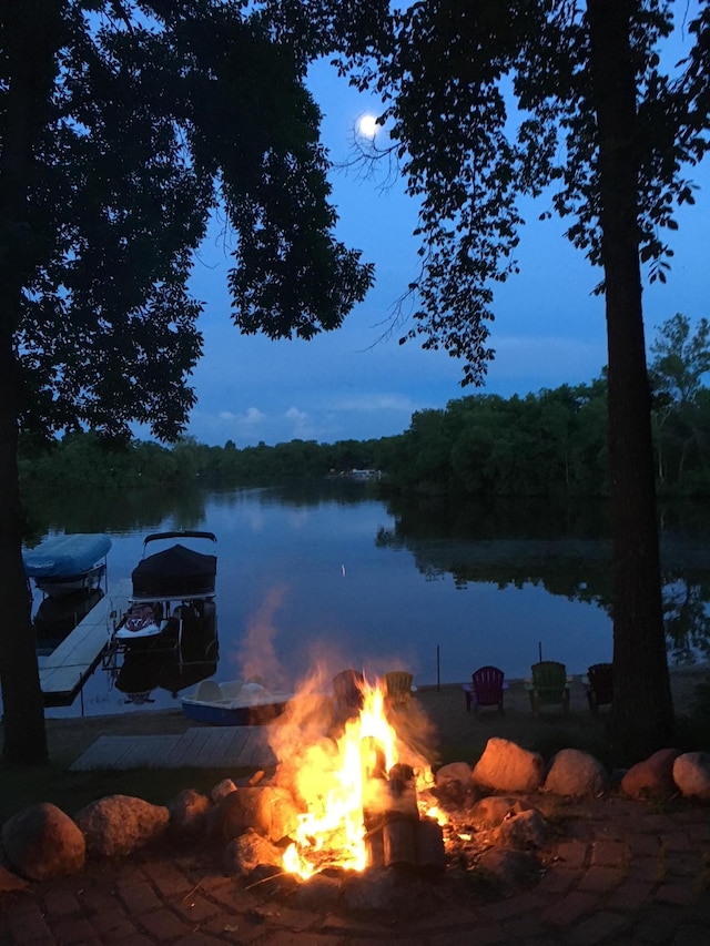 water view featuring an outdoor fire pit and a boat dock