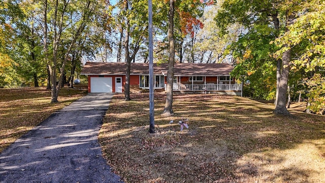 ranch-style house with a garage, covered porch, and driveway